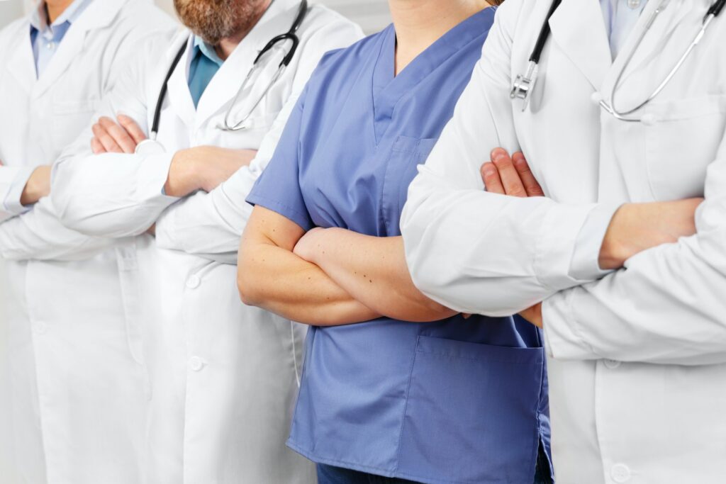 Doctors and nurses in healthcare team with arms crossed in a row in hospital